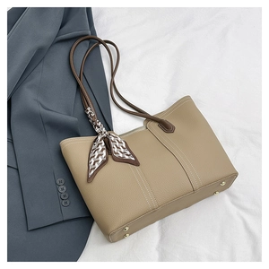 Detail of khaki pebbled leather tote with decorative scarf and contrast stitching