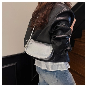 Détail du sac selle argenté montrant le cuir grainé et l'ornement en sphère métal