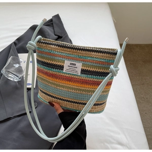 Close-up of a multi-color striped woven bucket bag with blue rope handles and logo patch