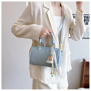 Light blue pebbled leather Boston bag with gold buckle and rainbow charm detail
