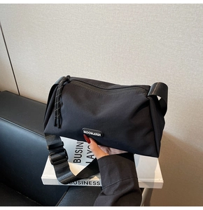 Gros plan sur le sac bandoulière en nylon noir avec sangle large et logo MOONLERSA