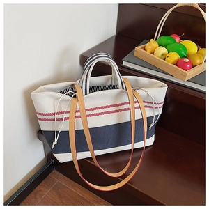 Nahaufnahme von Canvas-Shopper mit roten und blauen Streifen und braunen Trageriemen