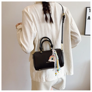 Detailed back view of a black pebbled leather Boston bag with a rainbow tassel charm