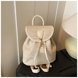 Detail of woven straw texture and beige PU leather flap on the summer backpack