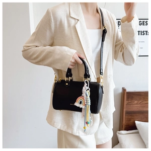 Detail of black pebbled leather Boston bag with rainbow charm and adjustable strap