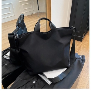 Detail view of large black tote bag with durable nylon fabric and detachable wide shoulder strap