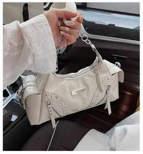 Détail du sac à clous blanc crème avec chaîne argentée et fermetures éclair en métal