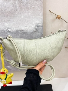Light green croissant shoulder bag in lychee leather with cute duck charm accessory