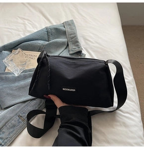 Détail du sac bandoulière en toile noire avec logo MOONLEASA et cordon de fermeture