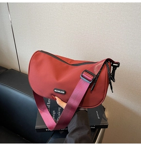Detail of red crescent shoulder bag with MOONLEASA logo and adjustable black strap