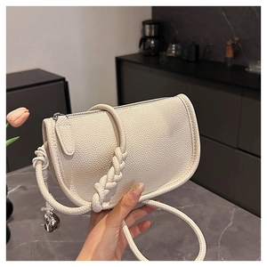 Détail du sac selle en cuir grainé blanc avec une bandoulière épaisse en tissage unique