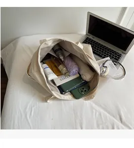 Spacious interior of beige canvas tote bag showing laptop, umbrella and daily essentials