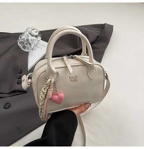 Détail du mini sac Boston en cuir PU blanc crème avec breloque cœur et double fermeture