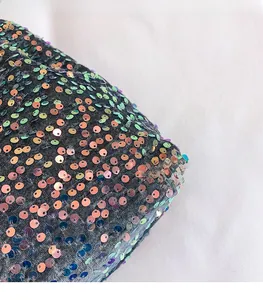 Close-up of deep gray knit fabric with colorful iridescent sequins on a tote bag