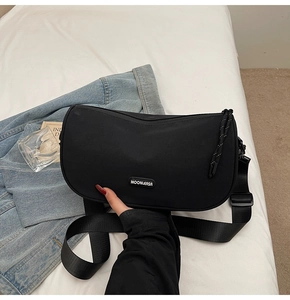 Detail of the black crescent crossbody bag showing nylon texture and MOONLERSA logo label