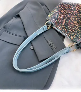Detail of glitter sequins tote bag with light blue leather strap and golden ring