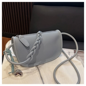 Détail du sac selle en cuir grainé avec pendentif en forme de cœur argenté brillant