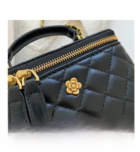 Detailed close-up of black quilted leather bucket bag with gold flower zipper