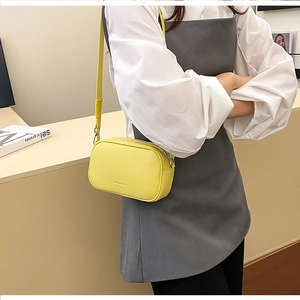 Dettaglio della borsa a tracolla gialla in pelle martellata con tracolla sottile