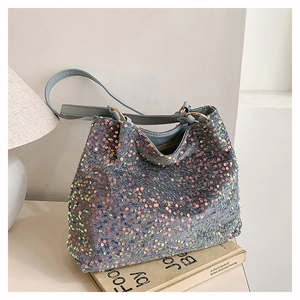Close-up of holographic sequins on the blue tote bag with metallic gold hardware