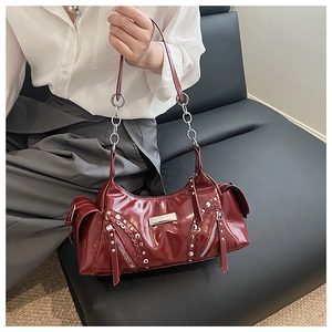 Détail d'un sac à main rouge foncé avec des rivets argentés et cuir synthétique poli