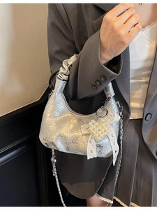 Silver pleated shoulder bag with chain strap and pearl heart charm on fashion model