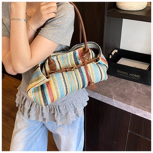 Detailed close-up of colorful woven texture and brown leather strap on summer tote bag