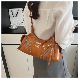Détails du sac à main vintage marron avec rivets argentés et pompon sur un sac style Boston