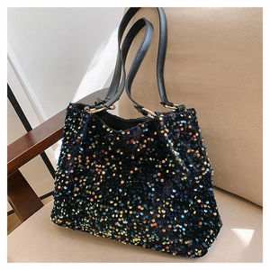 Detail of colorful sequins and golden metal ring hardware on a black tote bag