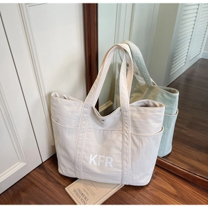 Detail view of large canvas tote bag with KFR print and practical side storage pockets