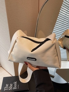 Sac bandoulière chic en toile crème avec large sangle et logo moderne en caoutchouc