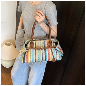 Detail of colorful striped woven straw shoulder bag with dark brown leather handles