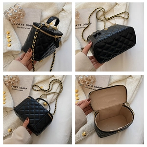 Detail of black quilted leather vanity case showing interior lining and chain strap