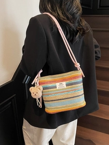 Colorful striped woven bucket bag with pink rope strap and plush bear charm accent