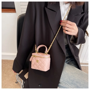 Pink quilted mini box bag with gold chain strap and floral buckle detail on model