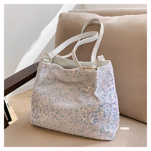 Detailed macro view of colorful shimmering sequins on a white fashion tote bag with gold rings