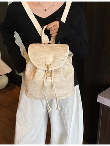 Beige woven straw backpack for women featuring drawstring closure and gold metal hardware