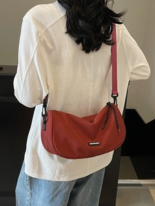Red half-moon crossbody bag made of durable nylon with adjustable fabric shoulder strap