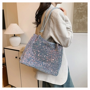 Detail of sequin tote bag showing colorful shimmering surface and blue strap on shoulder