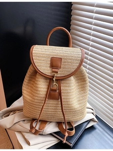 Large woven straw backpack with brown leather trim and metal hook for summer travel