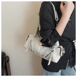 Détail du sac à bandoulière blanc crème avec rivets argentés et bandoulière chaîne