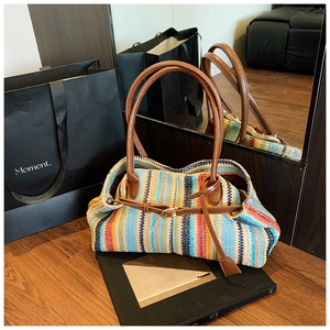 Detail of bohemian rainbow striped woven tote bag with brown leather handles and buckle