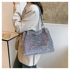 Detailed view of shimmering blue sequin tote bag with light blue faux leather straps