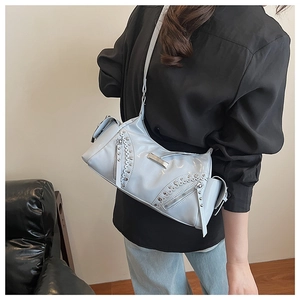 Vue latérale d'un sac à bandoulière bleu clair style Y2K avec rivets sur un mannequin
