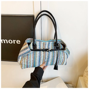 Detailed view of colorful wavy knit straw bag with black leather straps and buckle