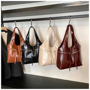 Sacs hobo en marron, noir, beige et bordeaux suspendus sur un présentoir métal