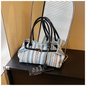 Detail of colorful zigzag woven texture and black leather handle on a summer bag