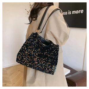 Detail showing the colorful sequins and black leather strap of this stylish tote bag