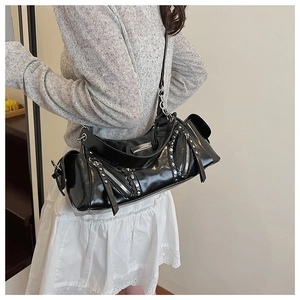 Vue latérale d'un sac porté épaule noir style punk avec rivets et fermetures éclair