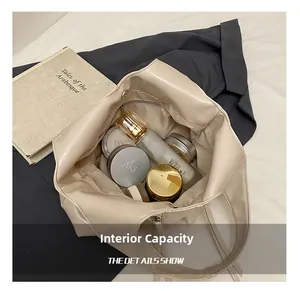 Détail de l'intérieur spacieux du sac cabas en similicuir crème avec des cosmétiques